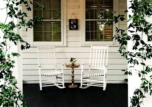 Two rocking chairs in front of a home